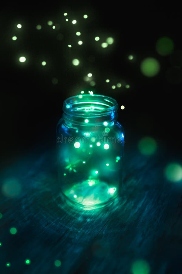 Fireflies in a glass jar on a dark background. Fireflies in a glass jar on a dark background