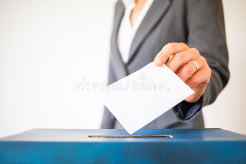 Elections - The hand of woman putting her vote in the ballot box