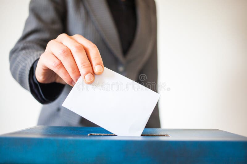 Elections - The hand of woman putting her vote in the ballot box