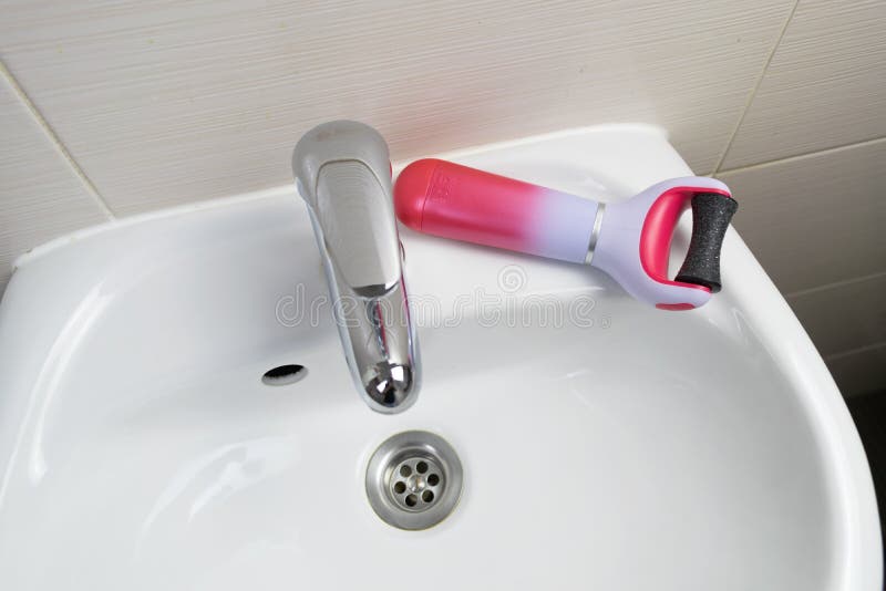 The main subject is out of focus, electric callus remover machine closeup remove old skin care treatment bathroom sink