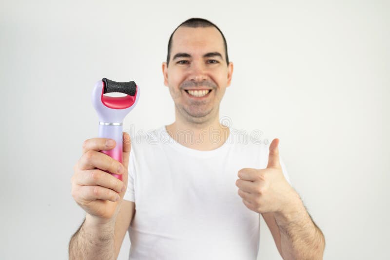 The main subject is out of focus, electric callus remover machine white background closeup remove old skin care treatment male hand hold happy smile thumbs up. The main subject is out of focus, electric callus remover machine white background closeup remove old skin care treatment male hand hold happy smile thumbs up