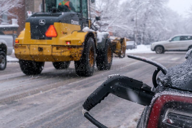 Electric Car Getting Charged in Montreal during Snowstorm Editorial