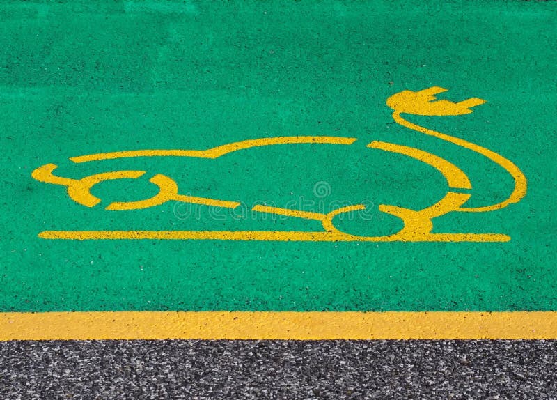 Electric car parking and charging sign. Yellow electric vehicle with plug painted on green background in the asphalt stock photos Electric car parking and charging sign. Yellow electric vehicle with plug painted on green background in the asphalt stock photos