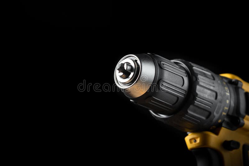 Electric drill closeup on a black background with wood and drills. Electrical tools. Hand battery screwdriver