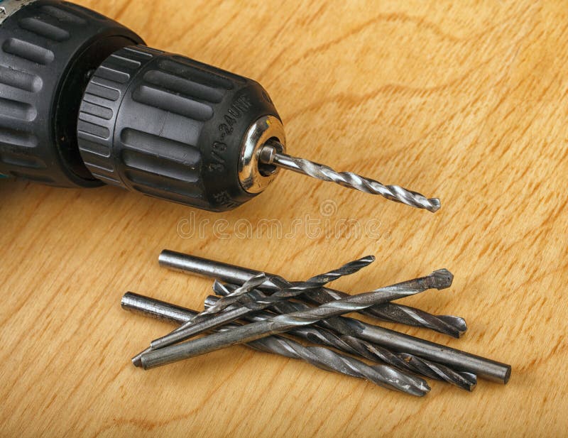 Cordless Drill and Large Screws on a Wood Background Stock Image