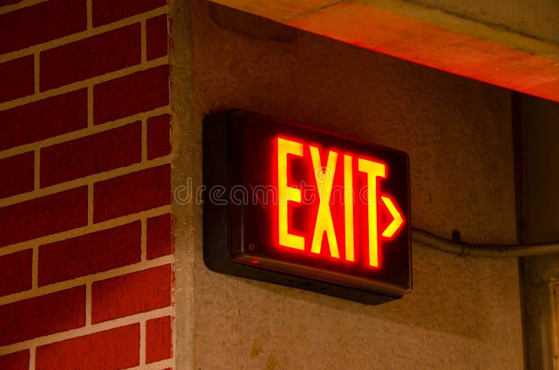 Electric Exit Sign on Brick Concrete Wall at Night Stock Photo Image