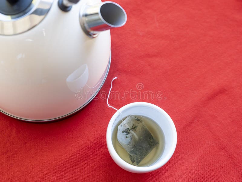 Electric Kettle with Boiling Water for the Herbal Tea. Tea Bag in a