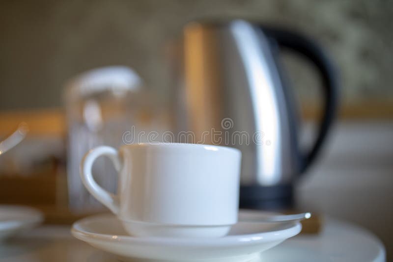 Modern electric kettle and cups of tea on white wooden table in kitchen.  Space for text Stock Photo by ©NewAfrica 317399329