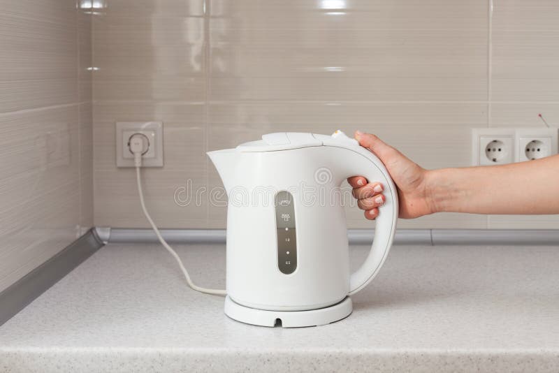 https://thumbs.dreamstime.com/b/electric-kettle-hand-background-kitchen-85348971.jpg