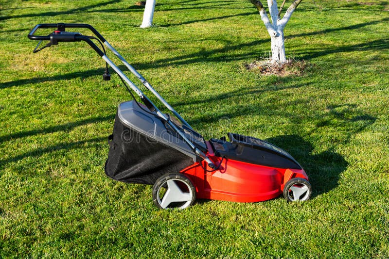 electric-lawn-mower-on-a-green-meadow-garden-equipment-stock-image