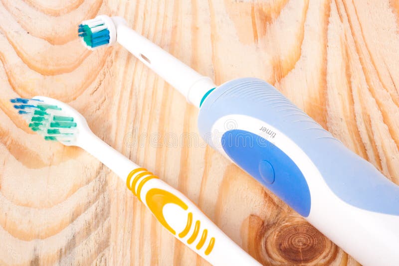 Electric and Manual Toothbrushes on the Wooden Background Stock Image