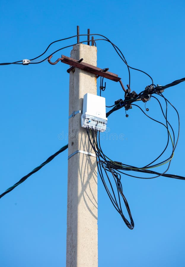An Electric Meter on a Pole Against a Blue Sky. Stock Photo Image of
