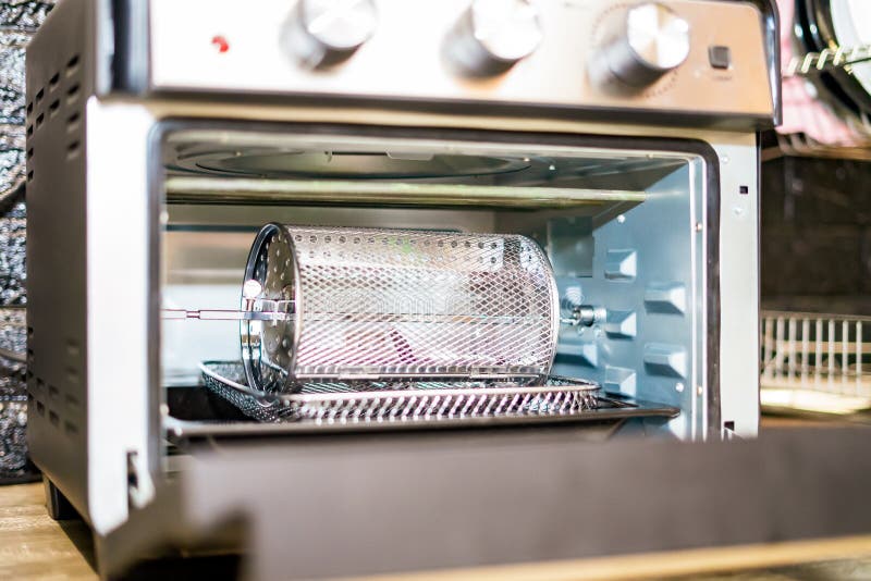 Electric Oven Cage or Rotating Basket Inside Air Fryer Oven. Modern Technology Kitchenware Stock