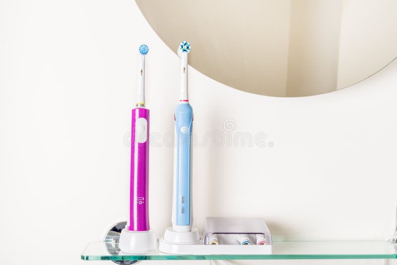 Electric Rechargeable Toothbrushes on the Bathroom Shelf Stock Image