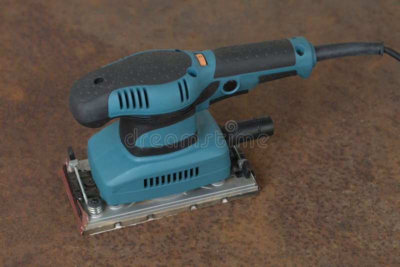 Electric Sheet Finishing Sander on Old Rusty Metal Sheet., on