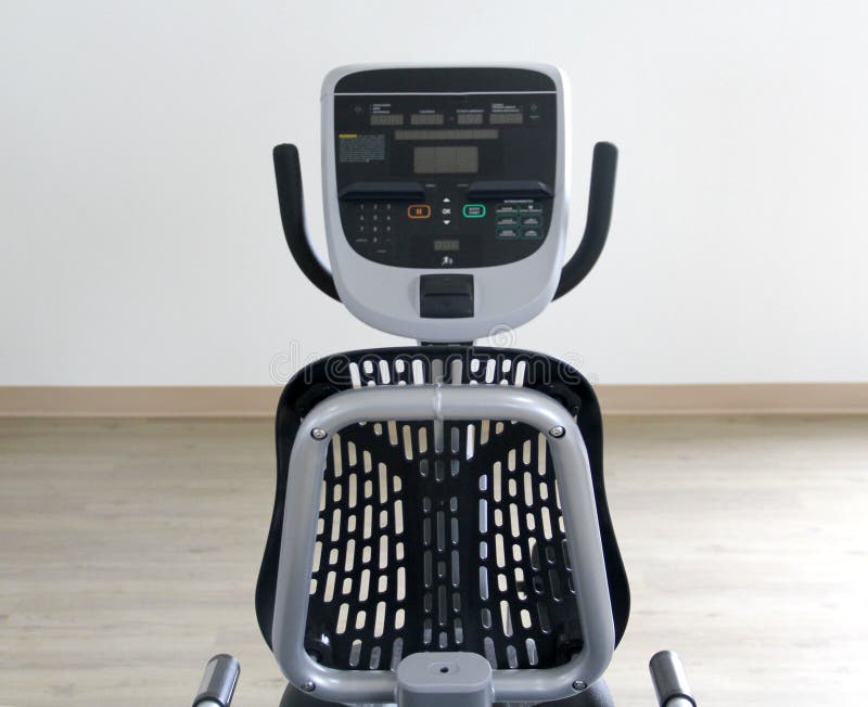 Black and white electric stationary recumbent bike in a gym for cardio, toning legs, burning calories and losing weight