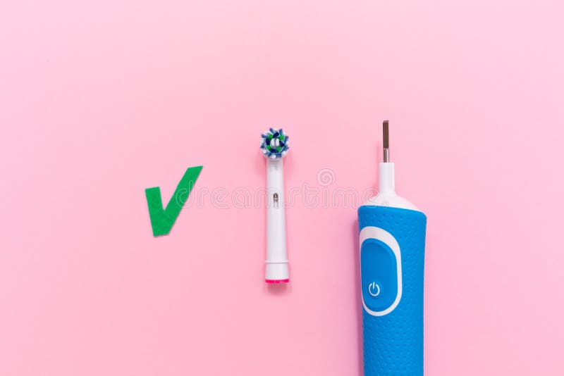 An electric toothbrush with brush head on pink background. Flat lay. Copy space. The concept of oral hygiene