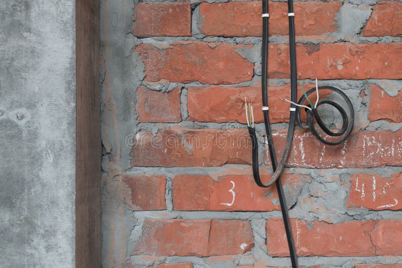 Electrical Cables are Fixed To a Brick Wall for Future Outlets Next To
