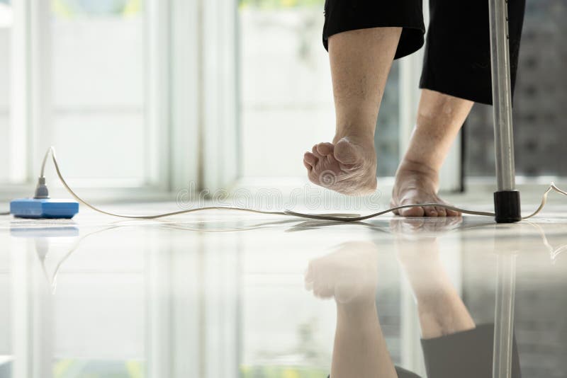 Electrical cord or socket cluttered on the floor,feet of senior woman stepping over obstacles,elderly people walking with