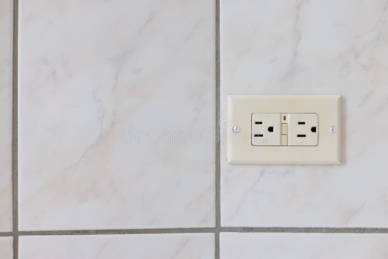 Electrical Plug Type B on the Tiled Wall in a Bathroom. Stock Photo