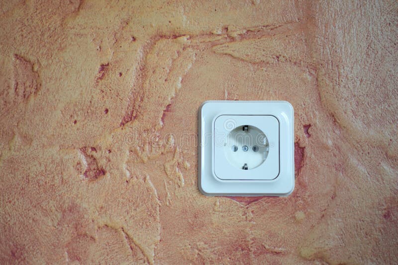 Electrical Socket on Red Brown Decorative Plaster Wall Stock Photo