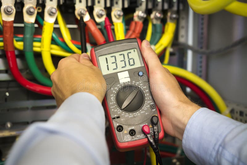 Electrical tester in hands of engineer close-up. Electrician technician at work inspecting cabling connection stock photography
