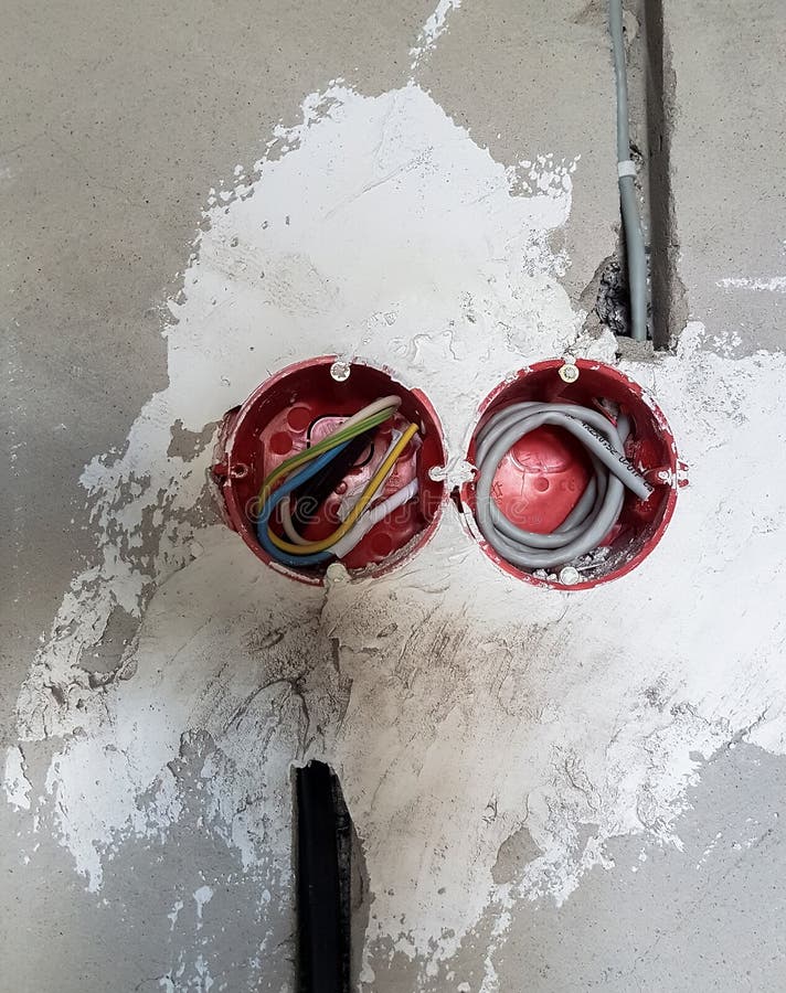Wiring. Sockets and Wires in Cement Wall Room Repair Stock Photo