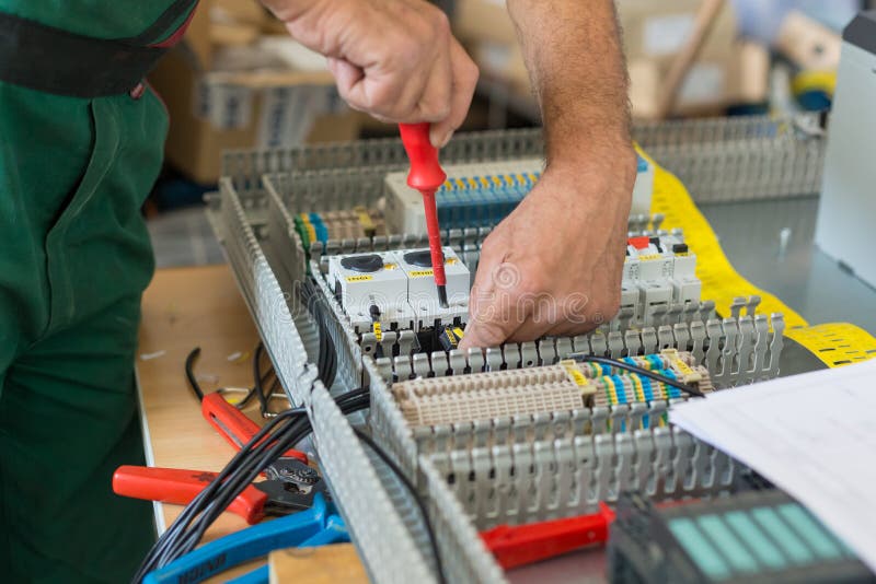 Electrician assembling industrial electric cabinet.