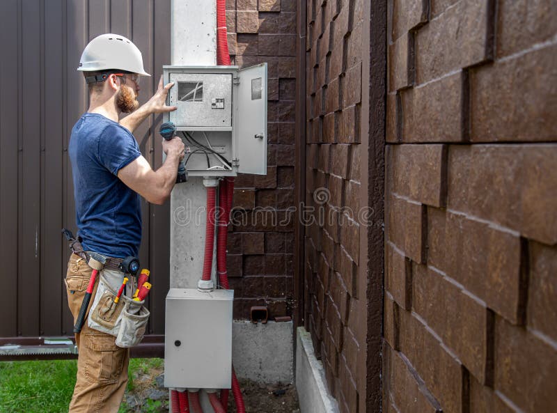 Electrician Builder at Work, Examines the Cable Connection in the