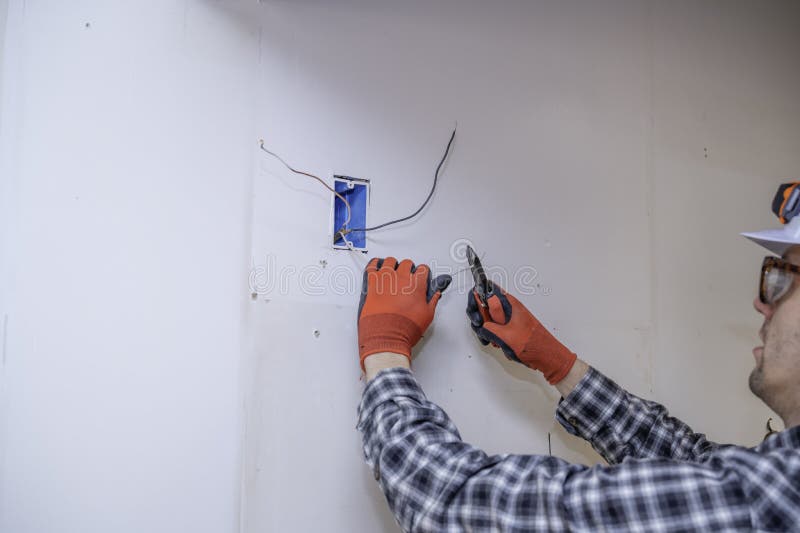 Electrician cutting wires in walls of new home constructions. Home electrician stock images, royalty-free photos and pictures