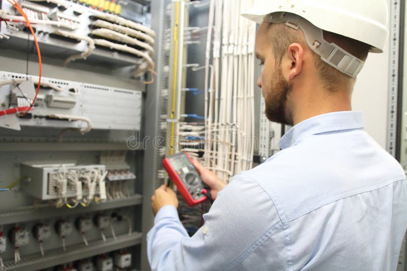 Electrician engineer tests electrical installations and wires on relay protection system