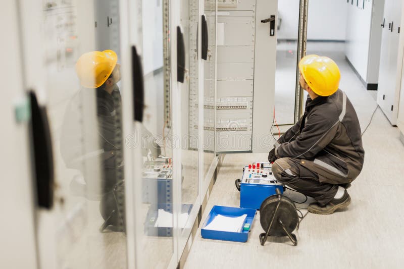 Electrician engineer tests system with relay test set equipment stock image