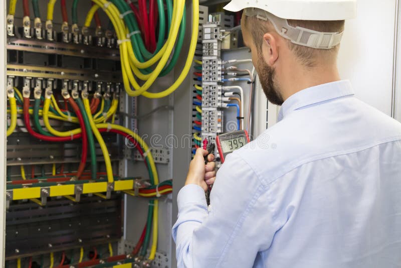 Electrician engineer at work inspecting cabling connection of high voltage power electric line stock photography