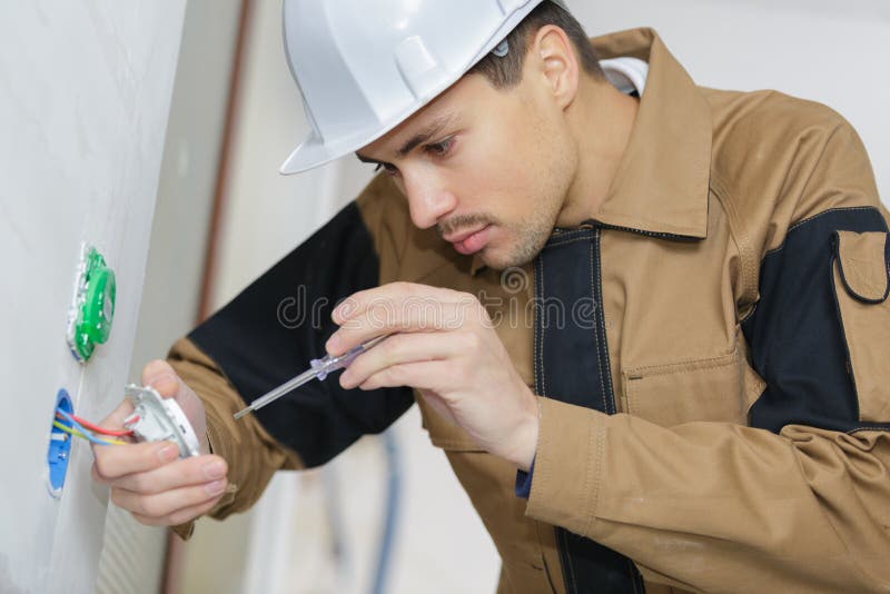Electrician hands with screwdriver installing wall socket stock photo Electrician hands with screwdriver installing wall socket stock photo
