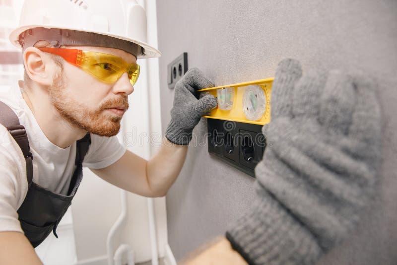 Electrician install switches and sockets checks tool levelness at home. Home electrician stock images, royalty-free photos and pictures