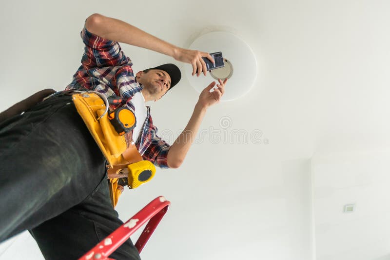 Electrician installer with a tool in his hands, working with cable on the construction site. Repair and handyman concept stock photo