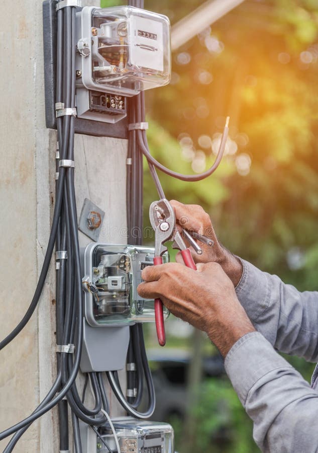 Electrician installing electric meter for measuring power into electric line distribution fuseboard royalty free stock photography Electrician installing electric meter for measuring power into electric line distribution fuseboard royalty free stock photography