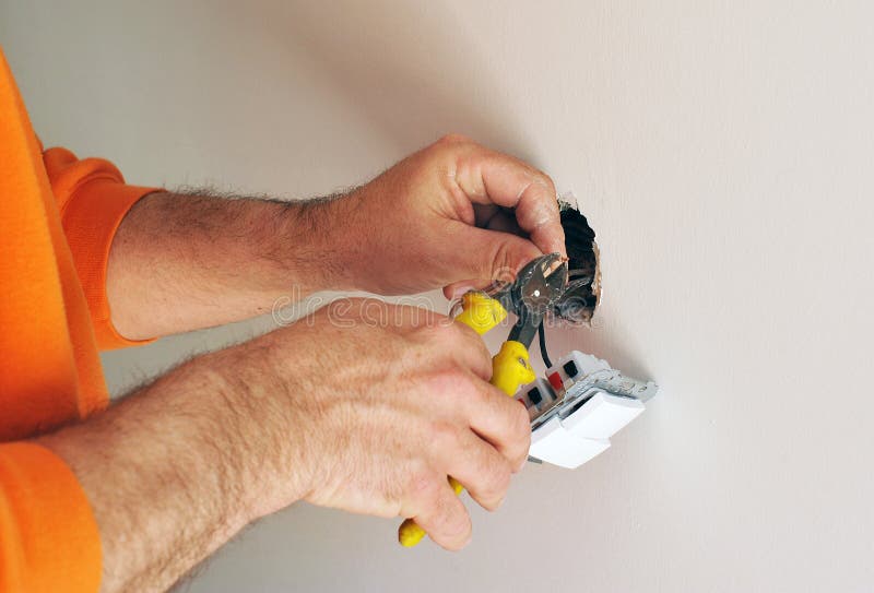 Electrician installing electrical switches in the new house stock photo Electrician installing electrical switches in the new house stock photo