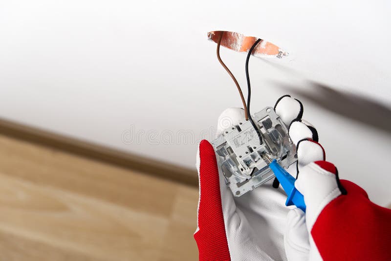 Electrician Installing Light Switch on Painted Wall with Screwdriver