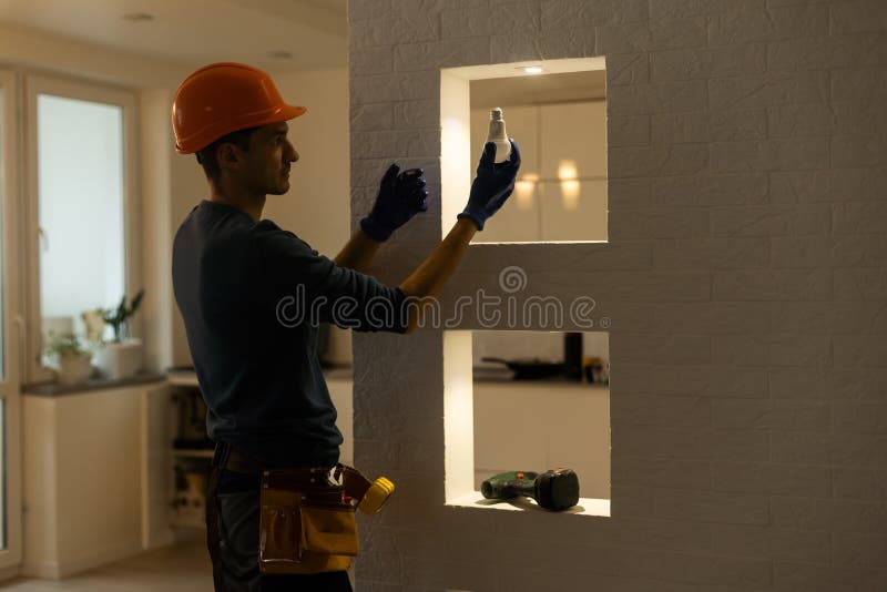Electrician installs lamp lighting and spot loft style royalty free stock photography