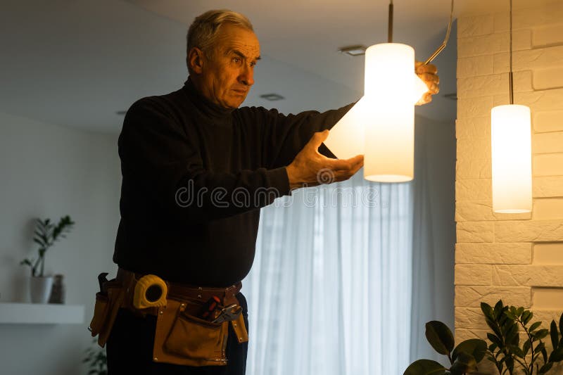 Electrician installs lamp lighting and spot loft style on ceiling royalty free stock photography