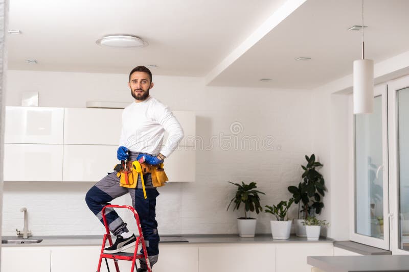 Electrician installs lamp lighting and spot loft style on ceiling. royalty free stock photo