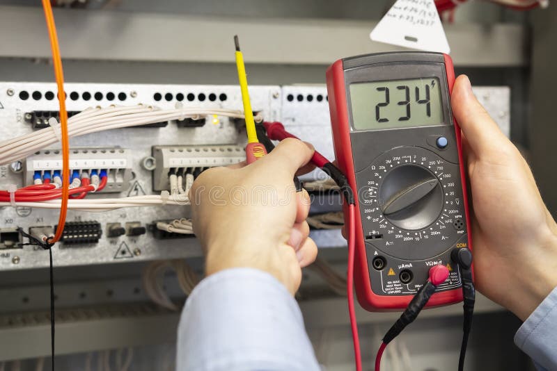 Electrician measurements with multimeter tester. Male Technician Examining Fusebox With Multimeter Probe stock photos