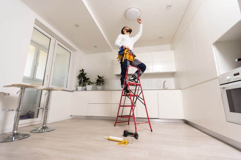 Electrician mounting ceiling lamp - installing the wires. royalty free stock image