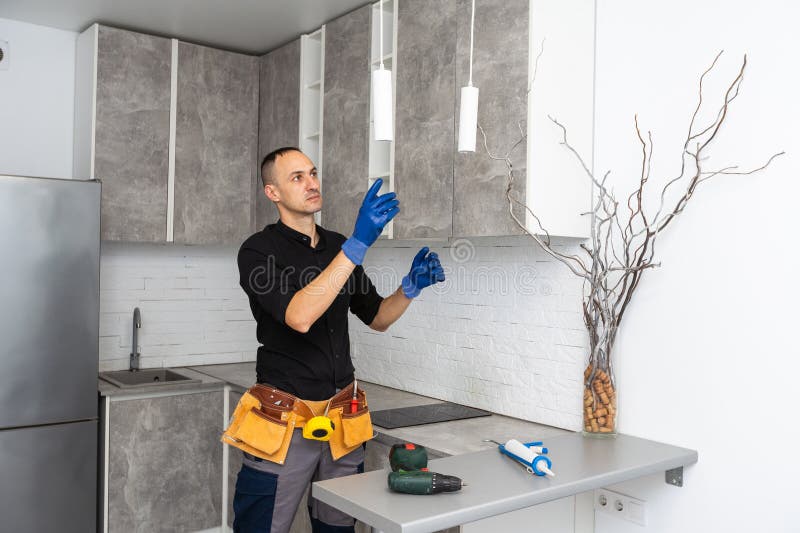 Electrician mounting ceiling lamp - installing the wires. stock photos
