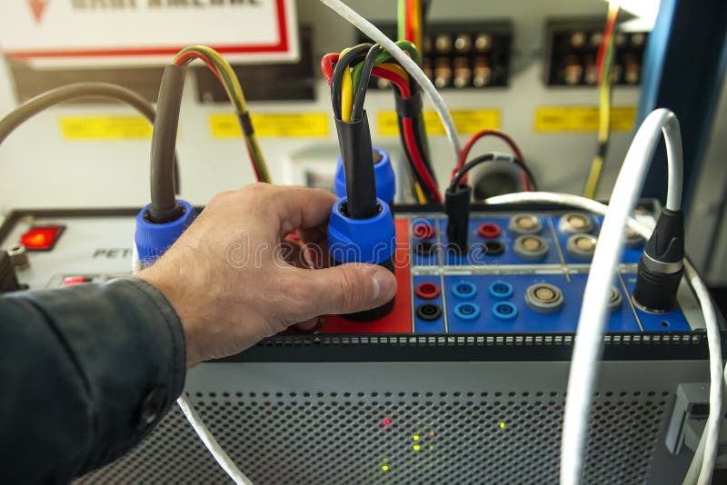 Electrician technician engineer with test device for testing relay protections of power high voltage lines, transformers stock image