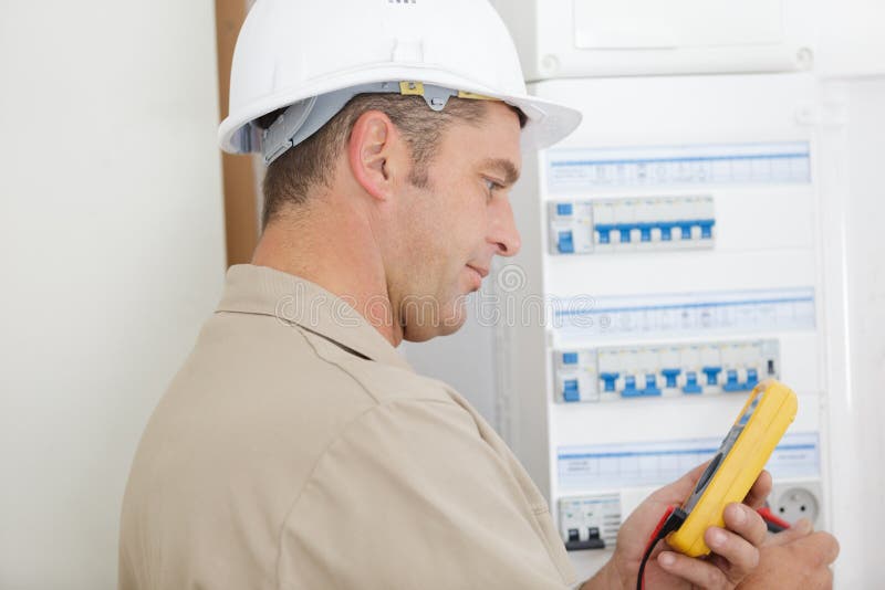 Electrician testing circuit breaker cabinet with multimeter royalty free stock photos Electrician testing circuit breaker cabinet with multimeter royalty free stock photos
