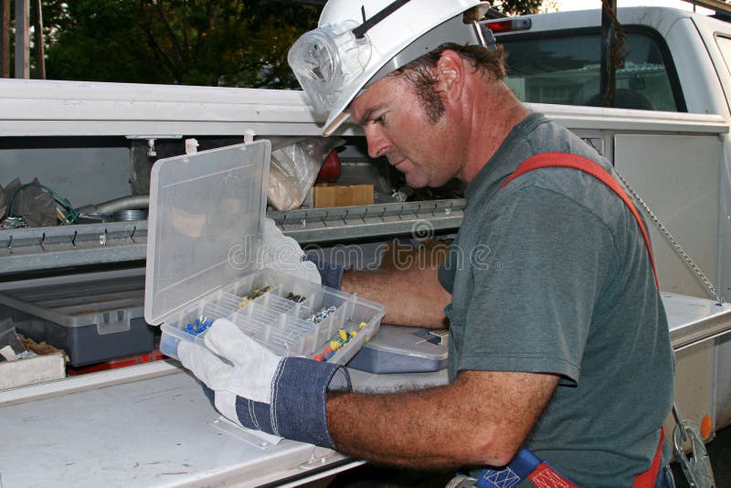 Electricista buscando en herramienta cabina sobre su servicio camión.