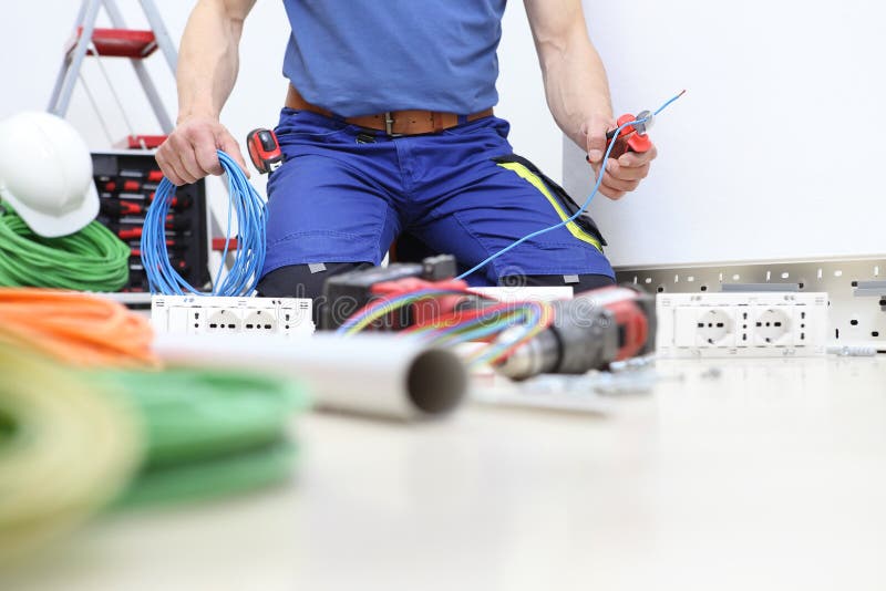 Electrician at work with nippers in hand cut the electric cable, install electric circuits, electrical wiring. stock image Electrician at work with nippers in hand cut the electric cable, install electric circuits, electrical wiring. stock image