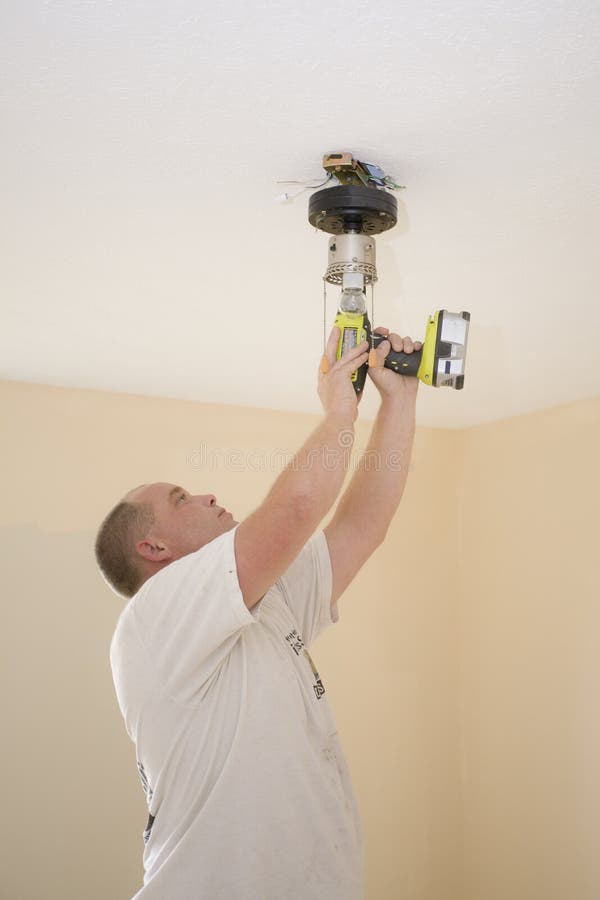 Electrician installing new light fixture and fan in bedroom for home that is going to be sold. Home electrician stock images, royalty-free photos and pictures
